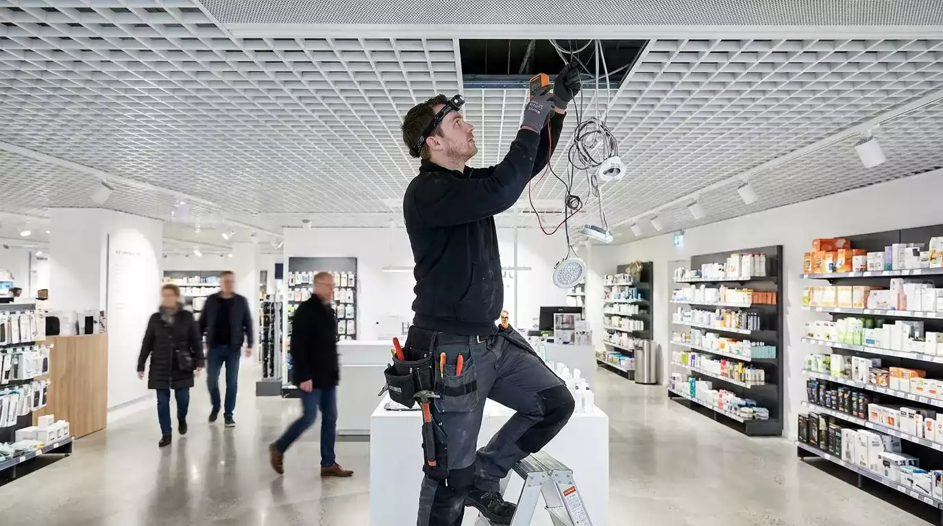 Eletricista profissional realizando manutenção em instalação elétrica externa